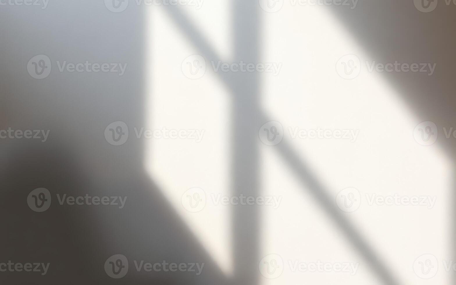 Light streaming through a window creates soft shadows on a wall in a quiet room during the afternoon photo