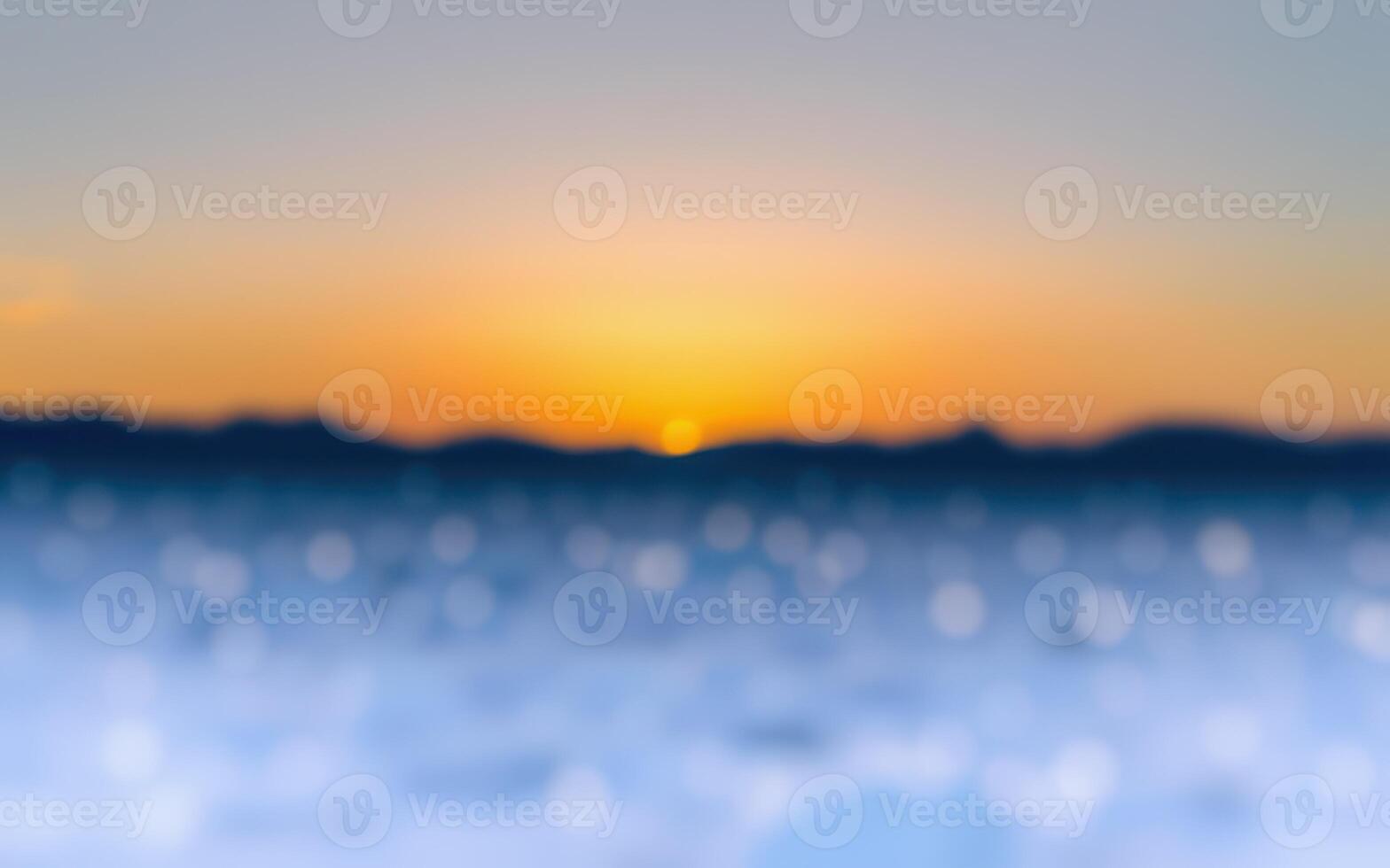Colorful sunset over calm water with blurred horizon and distant mountains in soft evening light photo