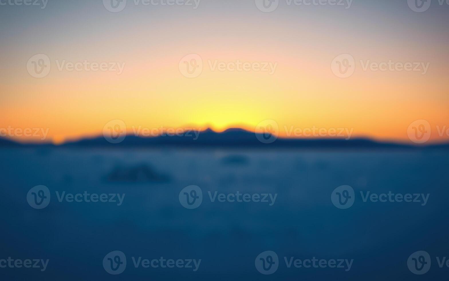 Serene twilight over distant mountains as the sun sets on a tranquil landscape photo