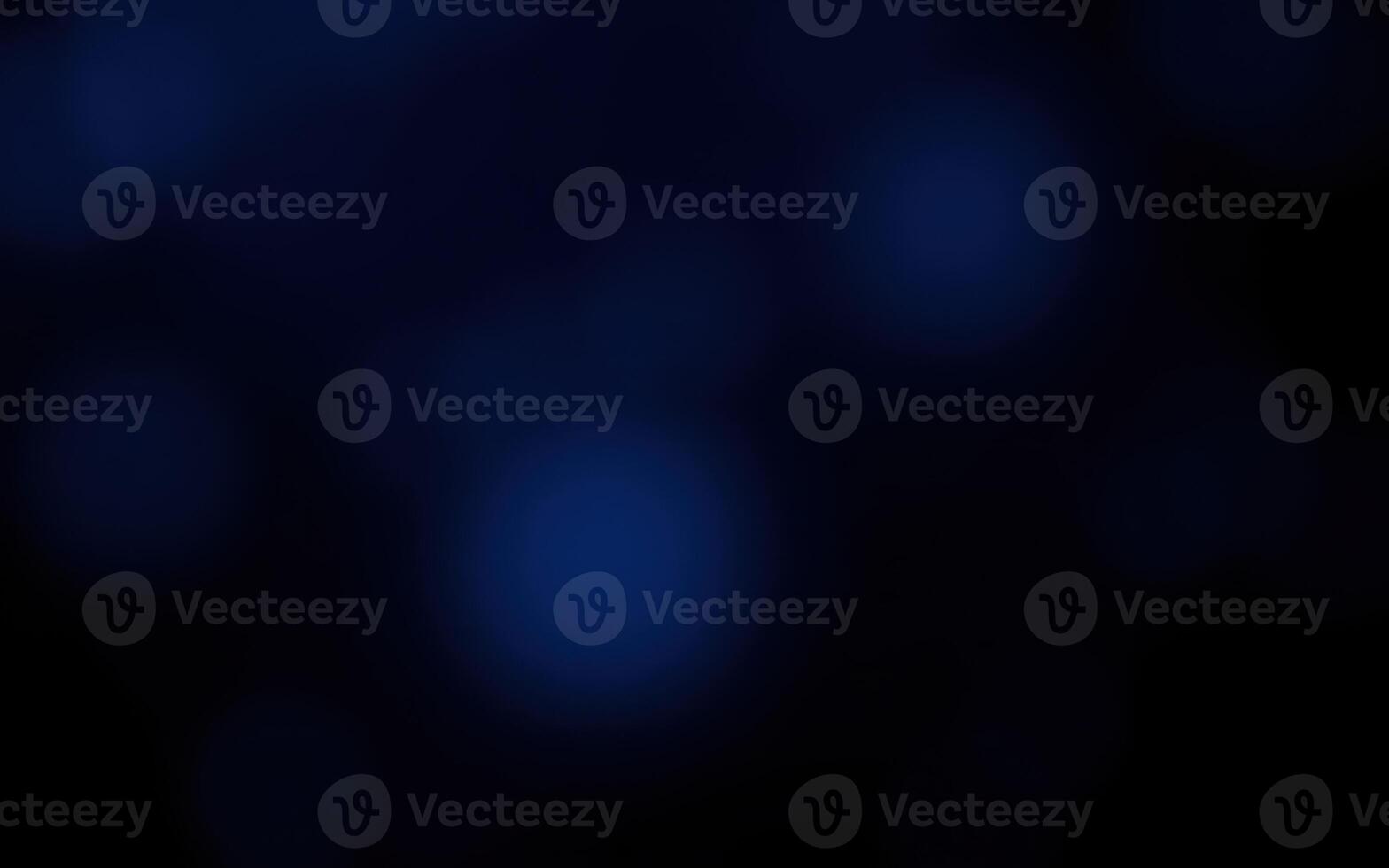 Soft blue orbs float in a dark space creating a mysterious and calming atmosphere at night photo