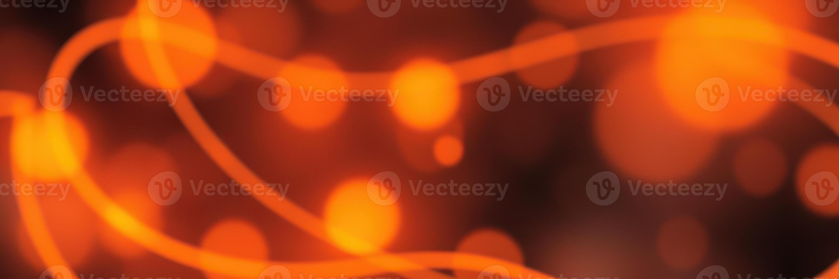 Vibrant orange lights create an abstract design with flowing lines and glowing circles over a dark background photo