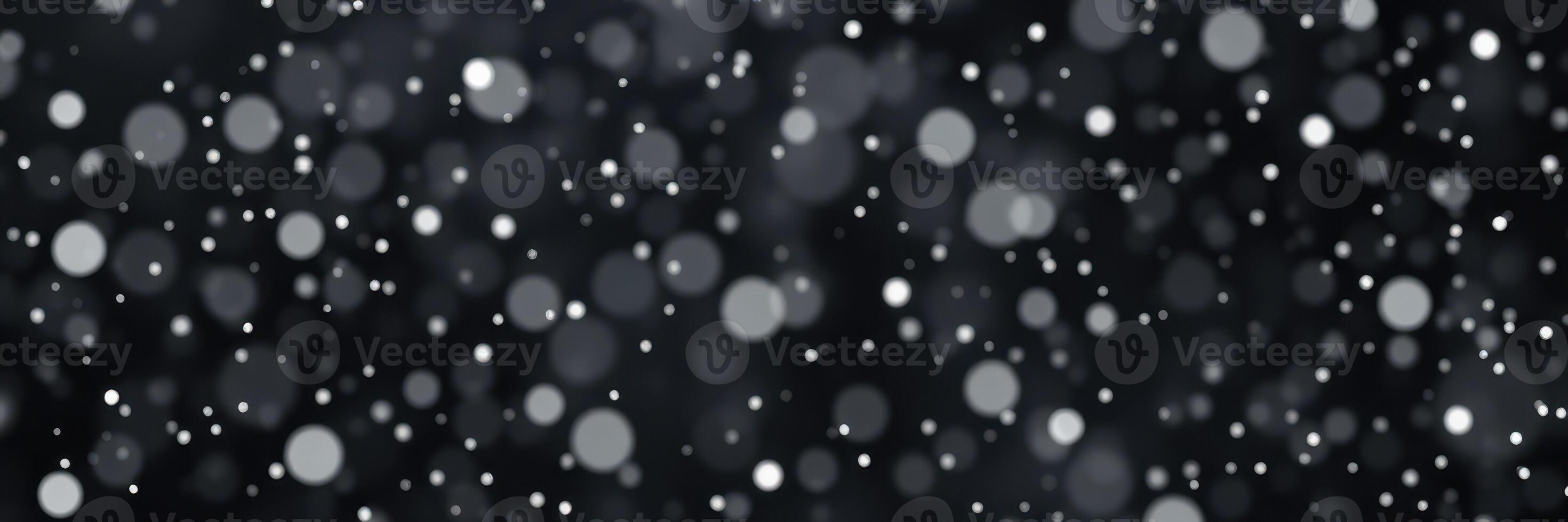 Soft white snowflakes gently fall against a dark backdrop creating a serene winter atmosphere photo