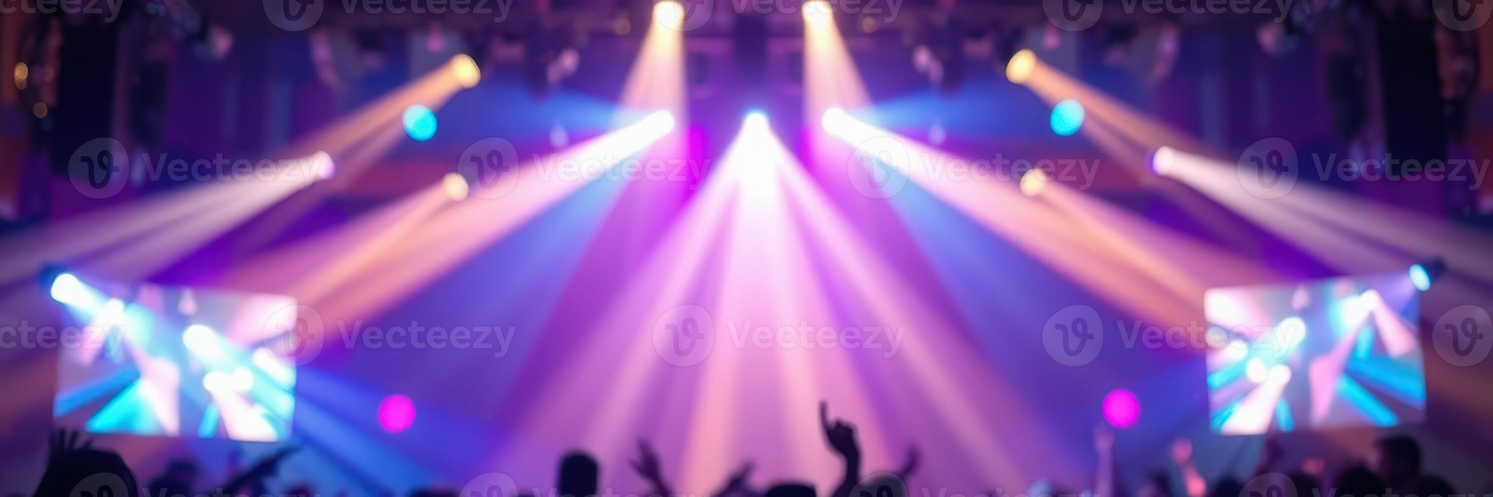 Colorful stage lights illuminate a lively night event with energetic crowd celebration photo