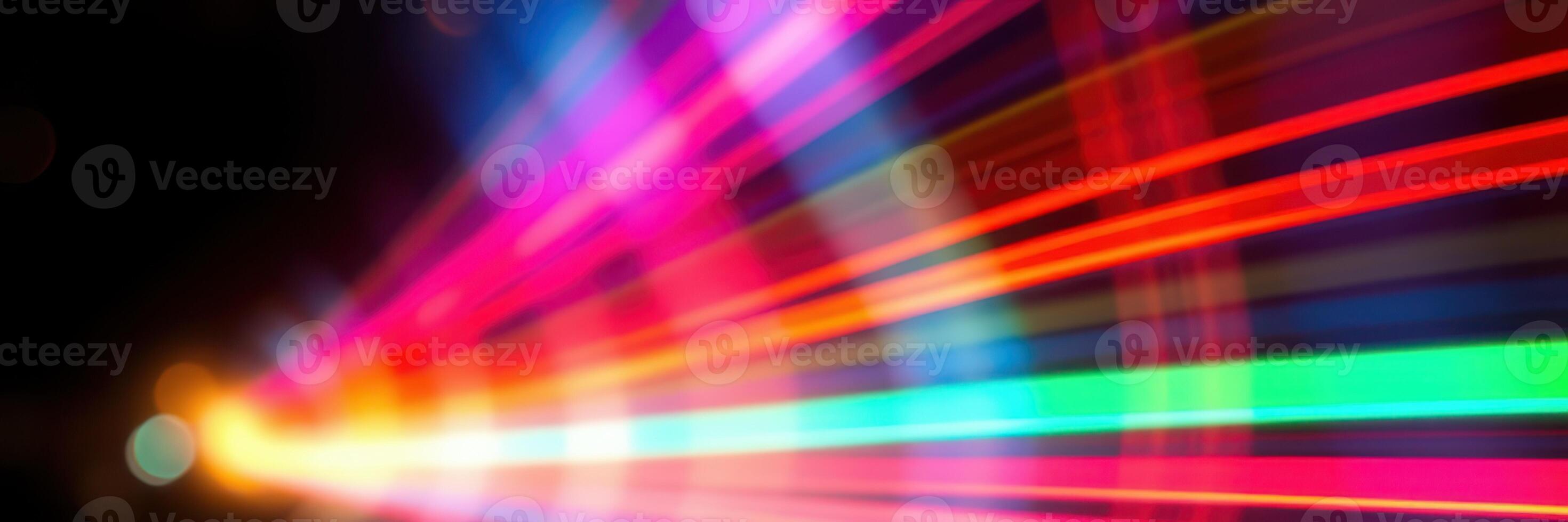 Colorful light streaks blurring across a dark background create a vibrant visual display at night photo