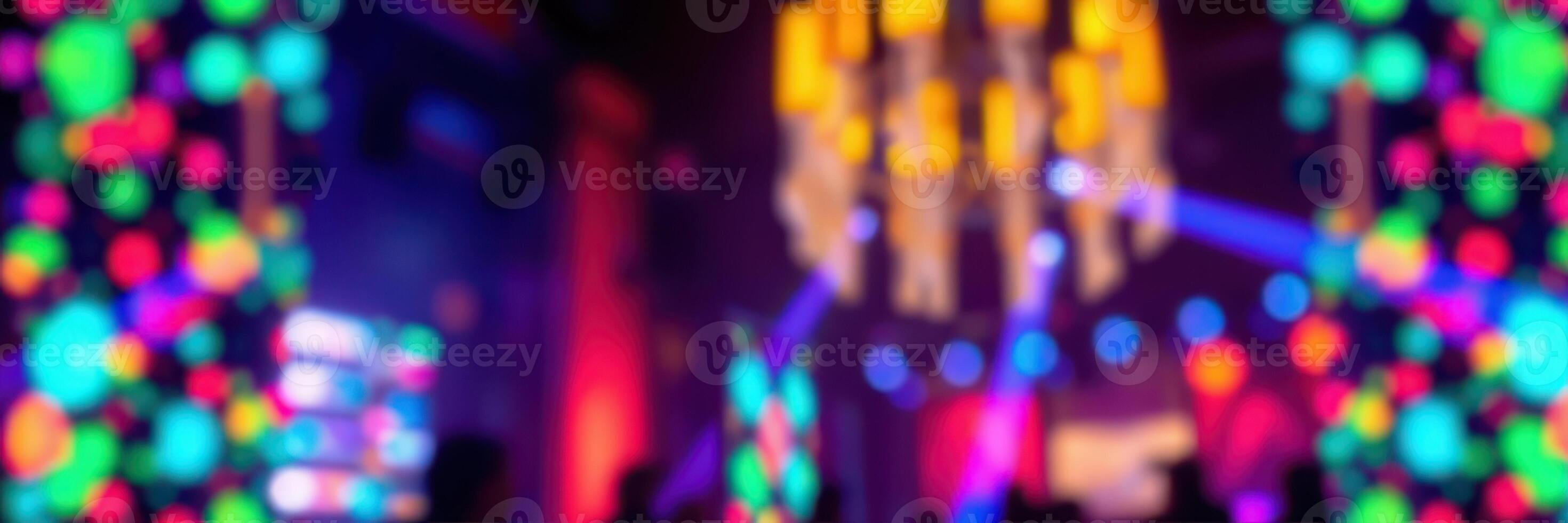Colorful lights create an energetic atmosphere during a lively electronic music event at a vibrant venue photo