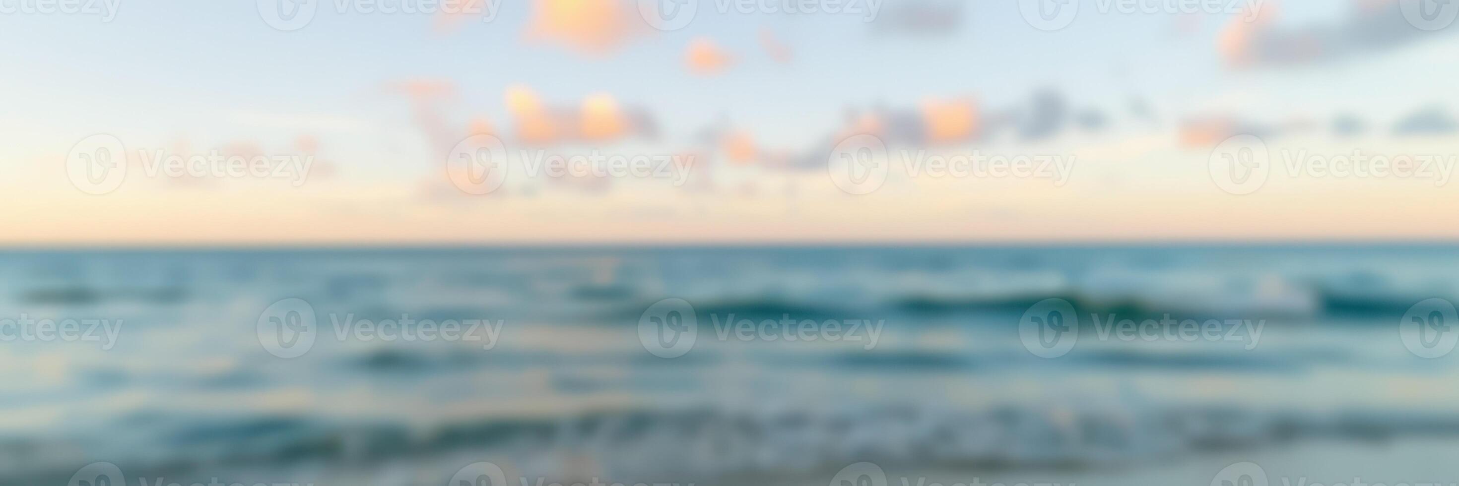 Beautiful sunset over calm ocean waters with gentle waves and pastel-colored clouds at twilight photo