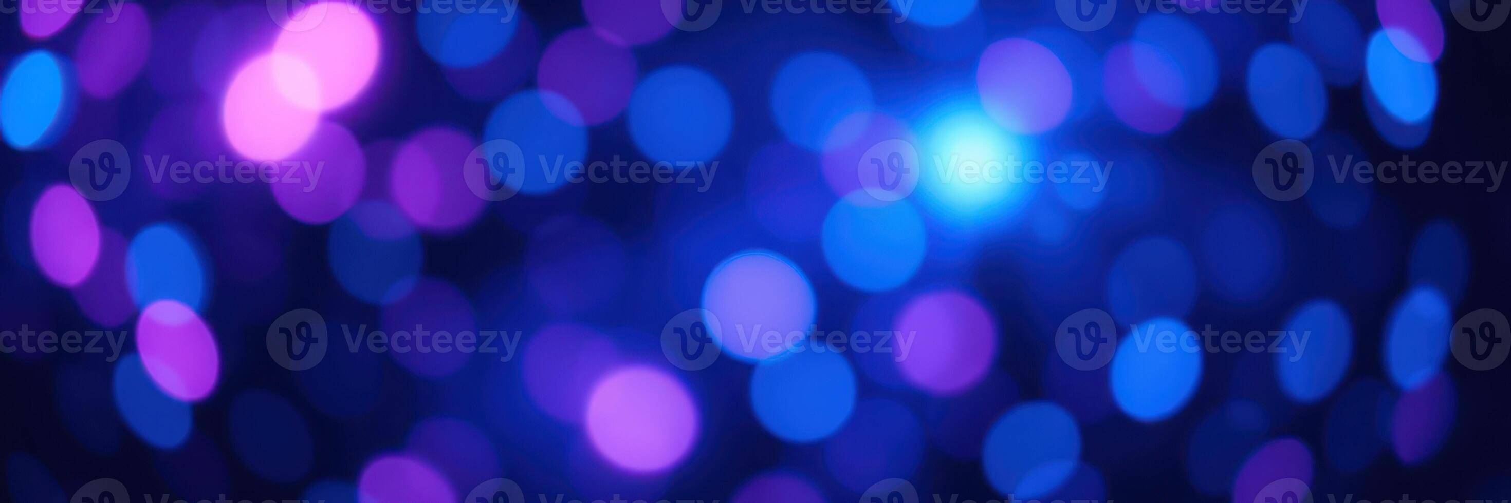 Vibrant bokeh lights create a captivating background with blue and purple hues during an evening event photo