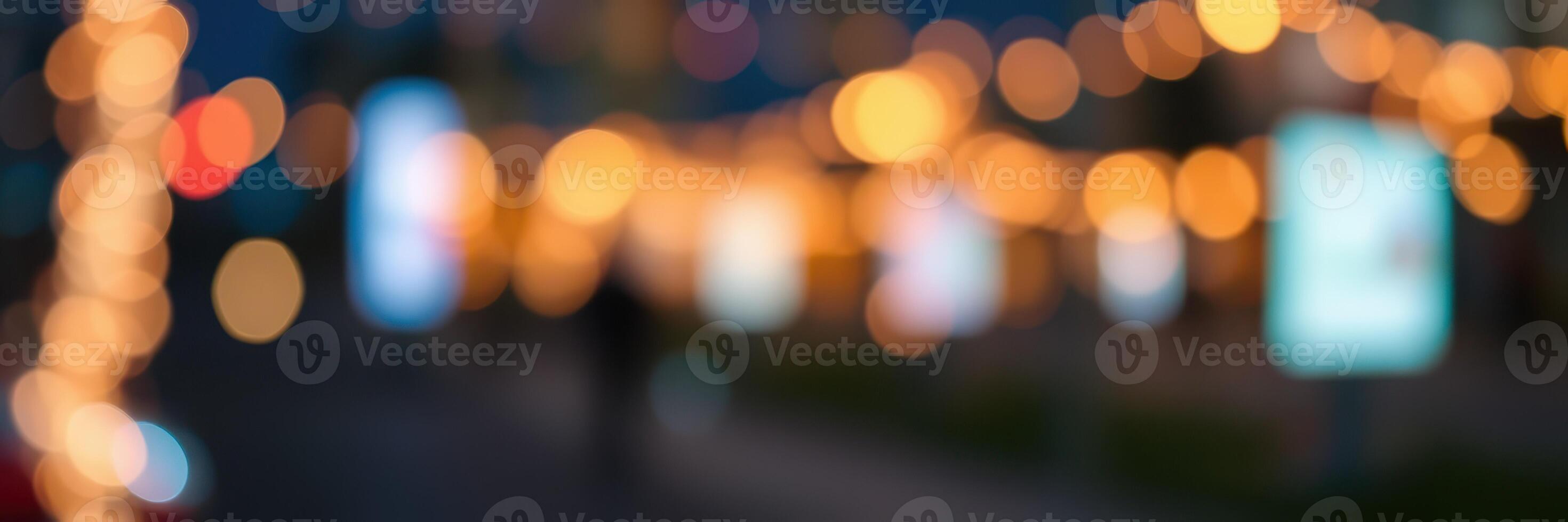 Evening stroll through a festive street adorned with glowing lights and blurred advertisements photo