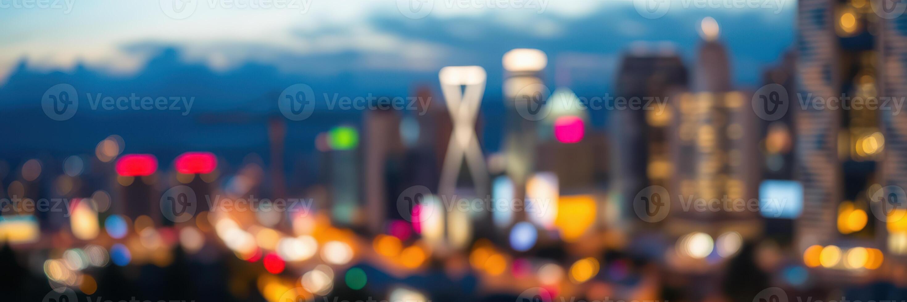 Colorful city lights illuminate the skyline at dusk with blurred outlines of buildings and vibrant signage photo