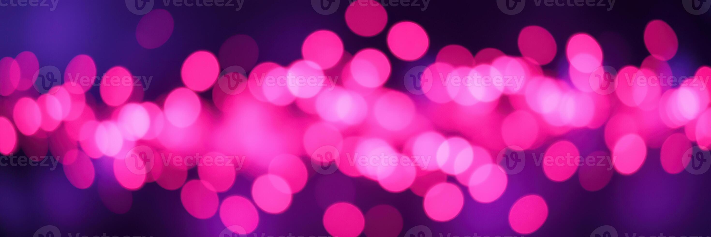 Vibrant pink bokeh lights create a dynamic atmosphere at an evening event in an urban setting photo