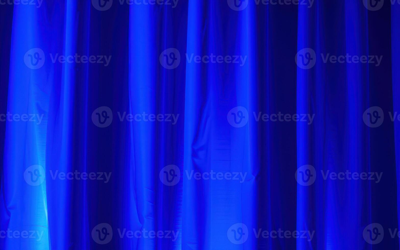 Bright blue curtain backdrop creating a vibrant atmosphere for a performance in an indoor venue photo