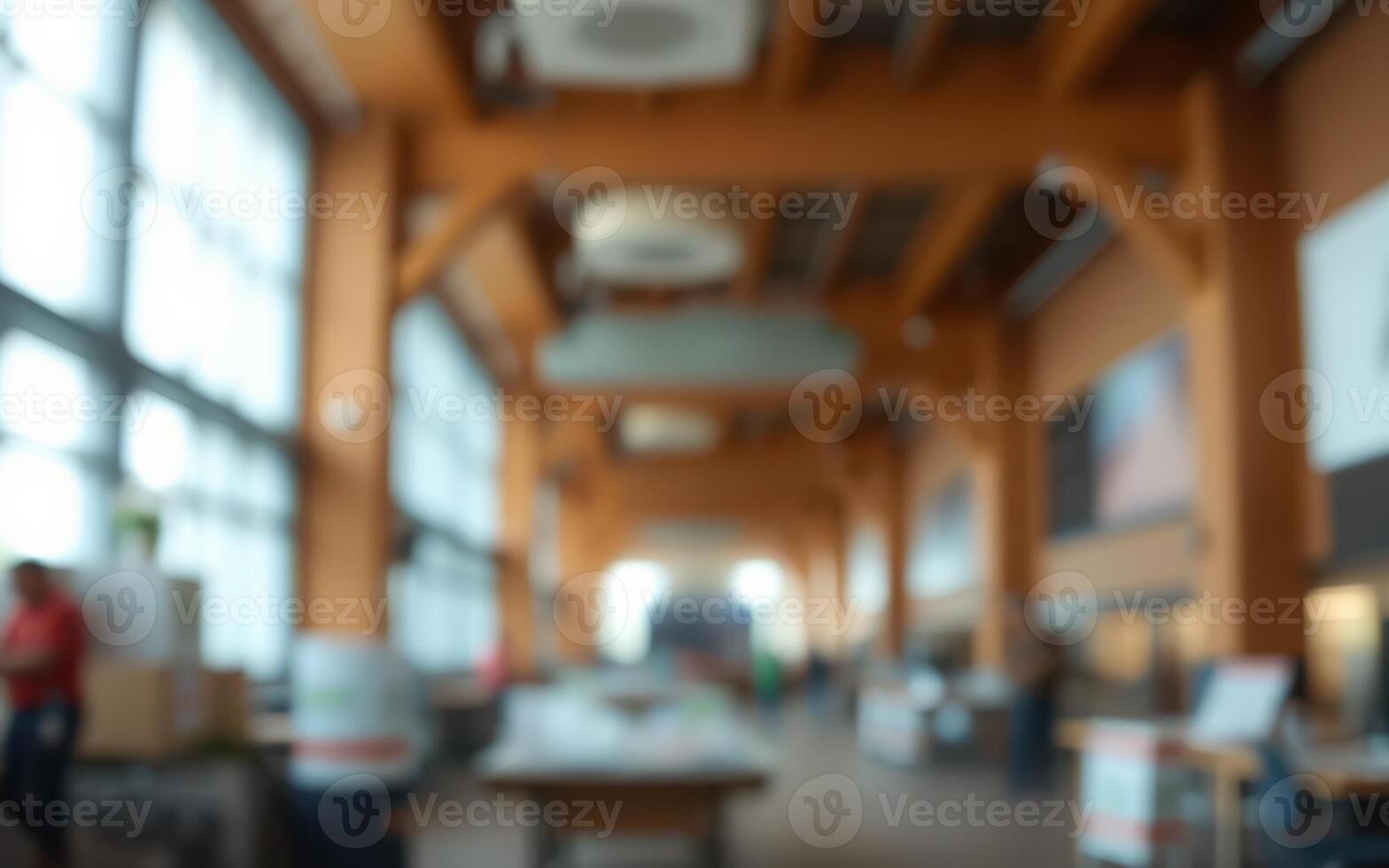 Bright interior of a spacious building with large windows and wooden beams filled with activity photo