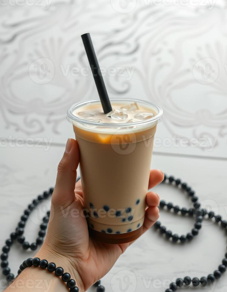 Enjoying a refreshing bubble tea with pearls in hand against a beautifully patterned backdrop photo