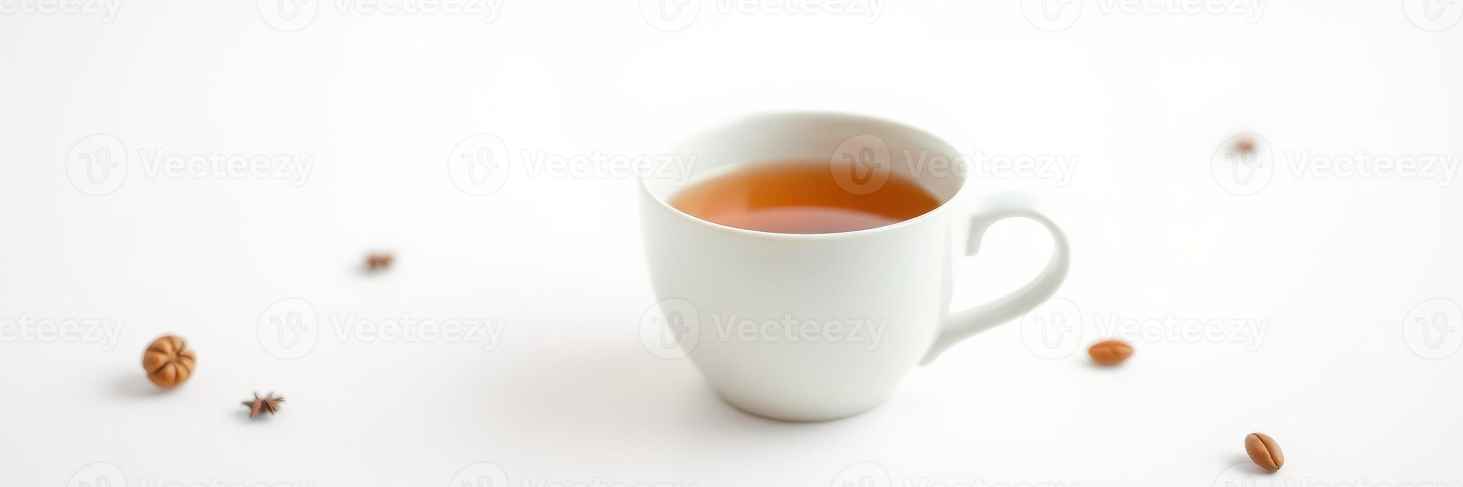 Warm cup of spiced tea sitting on a simple white table with scattered spices nearby photo