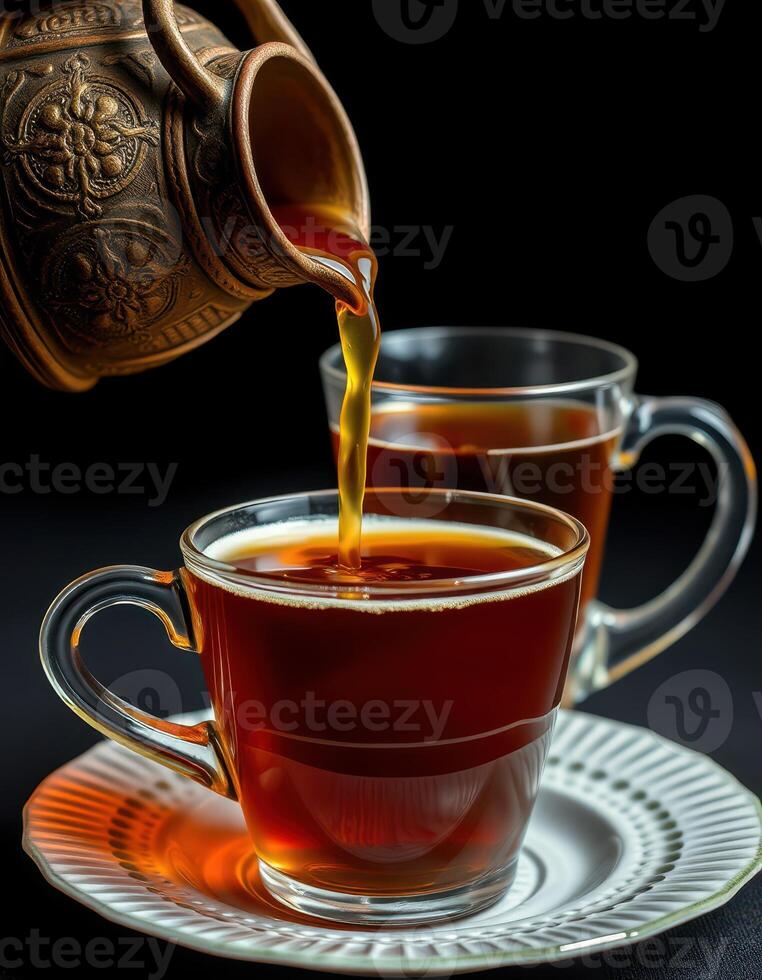 Pouring fragrant tea into clear glass cups placed on a white plate during a cozy afternoon gathering photo