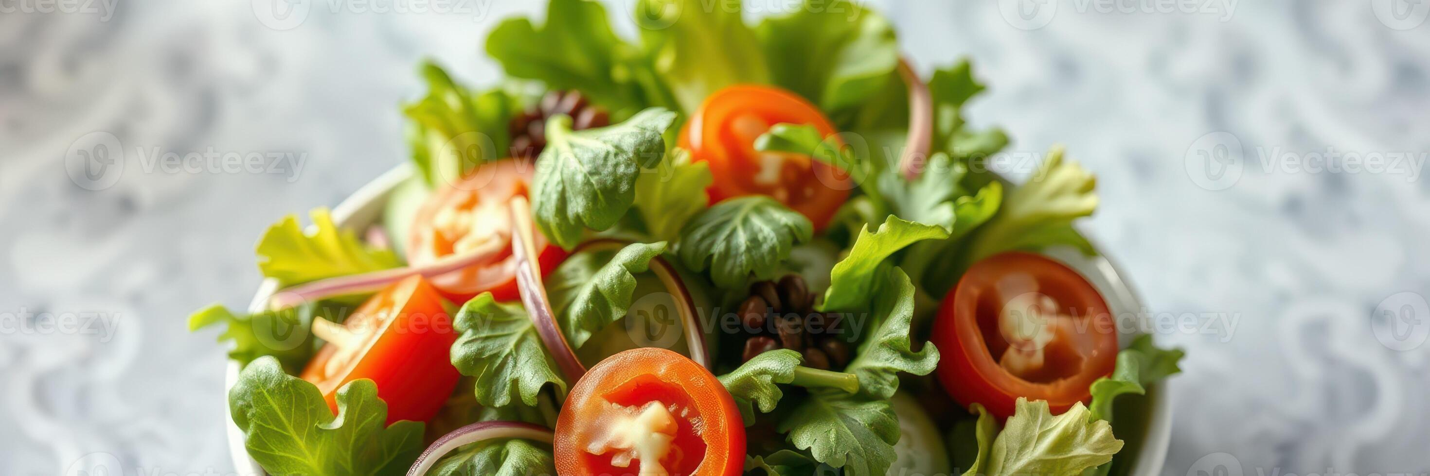 Fresh garden salad with tomatoes and herbs served in a bowl on a patterned table photo