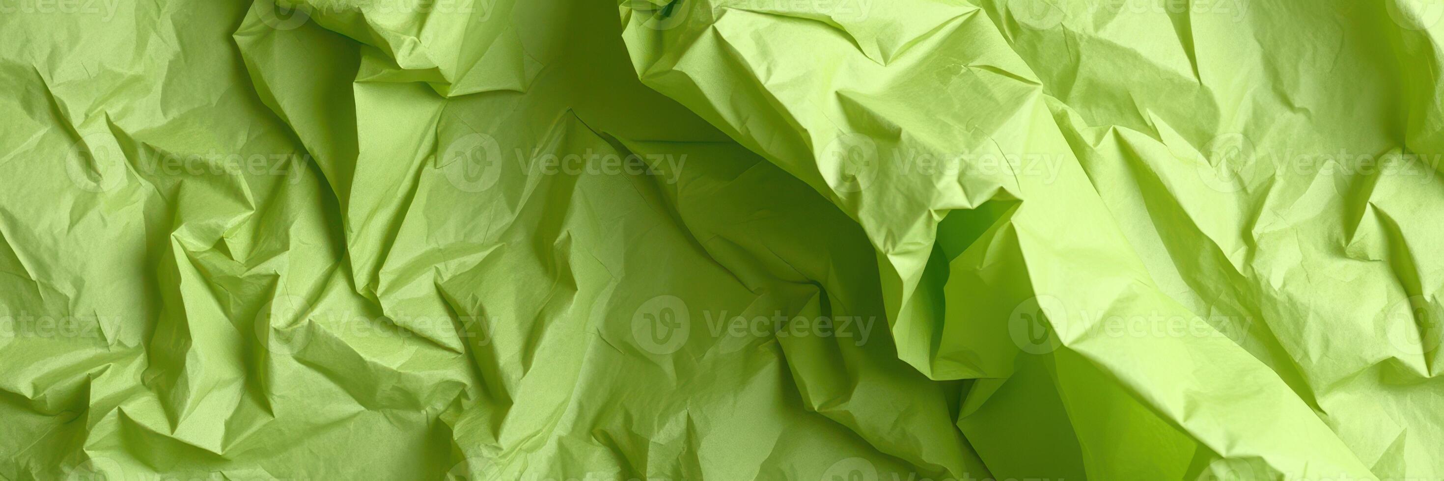 Wrinkled green paper creating abstract textures suitable for artistic backgrounds and craft projects photo
