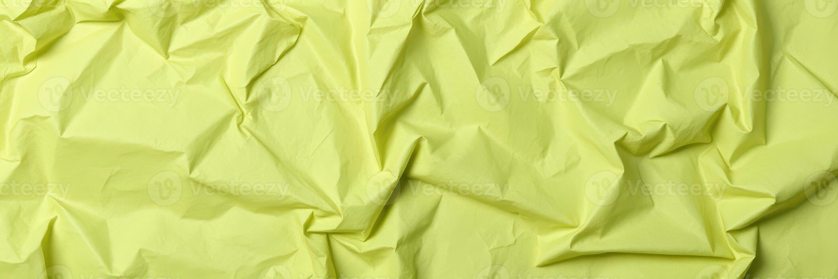Crumpled green paper texture highlights unique patterns and shadows from natural light during the day photo