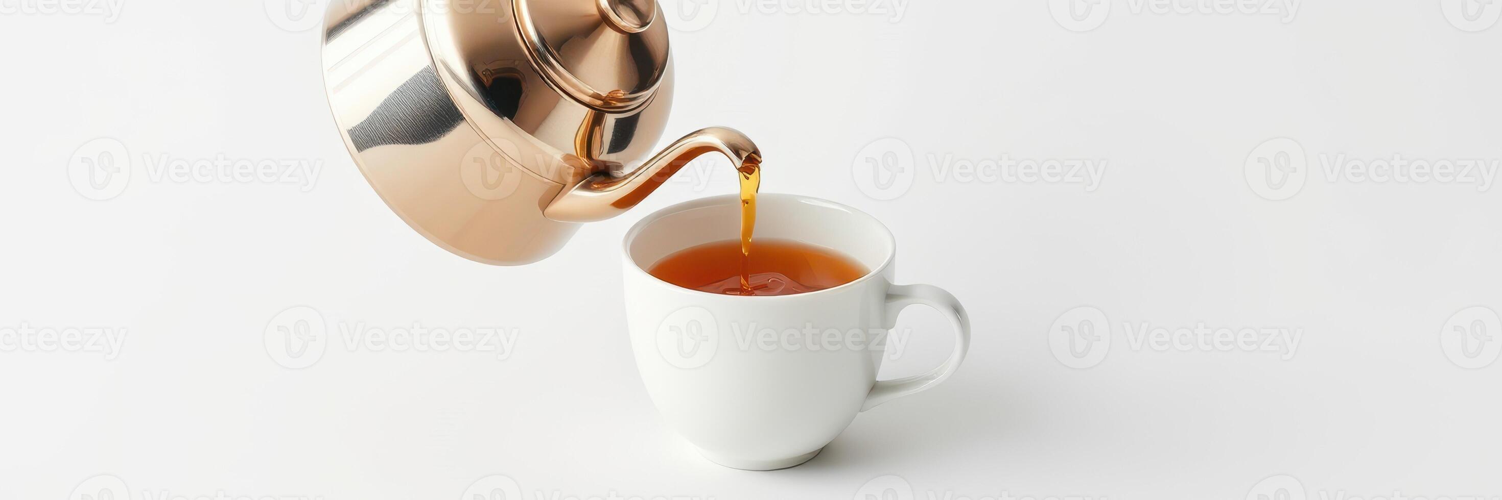 Pouring hot tea from a metal kettle into a white ceramic cup on a minimalist table photo
