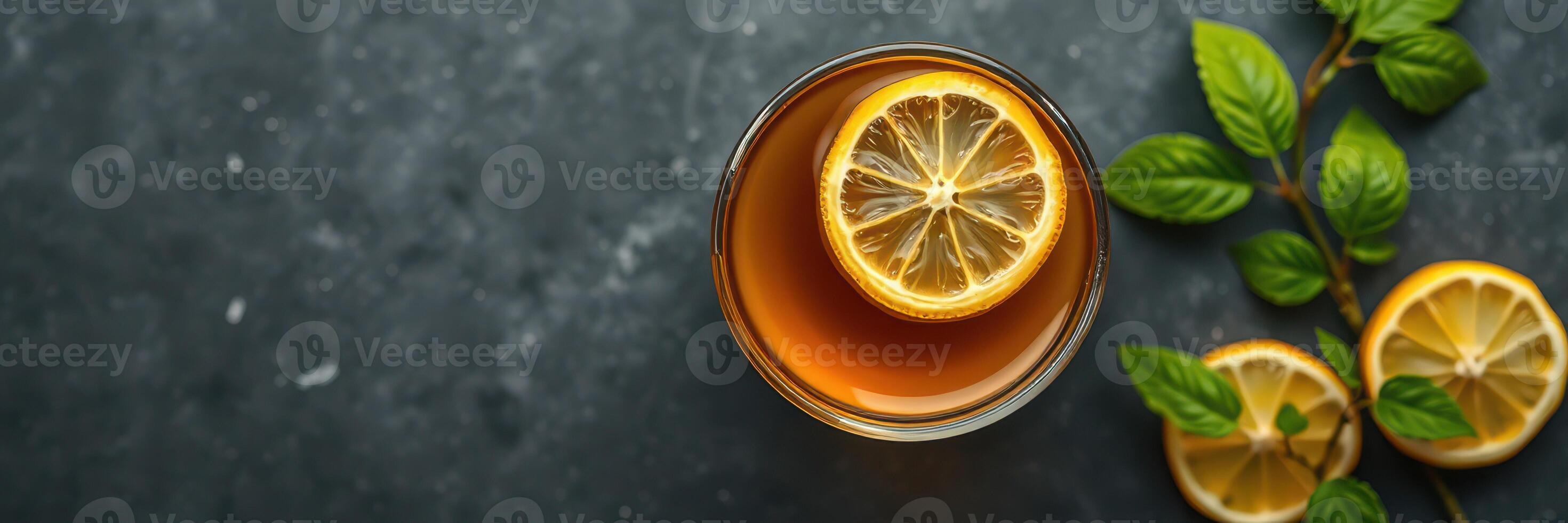 Refreshing iced tea with lemon and mint served on a dark countertop photo