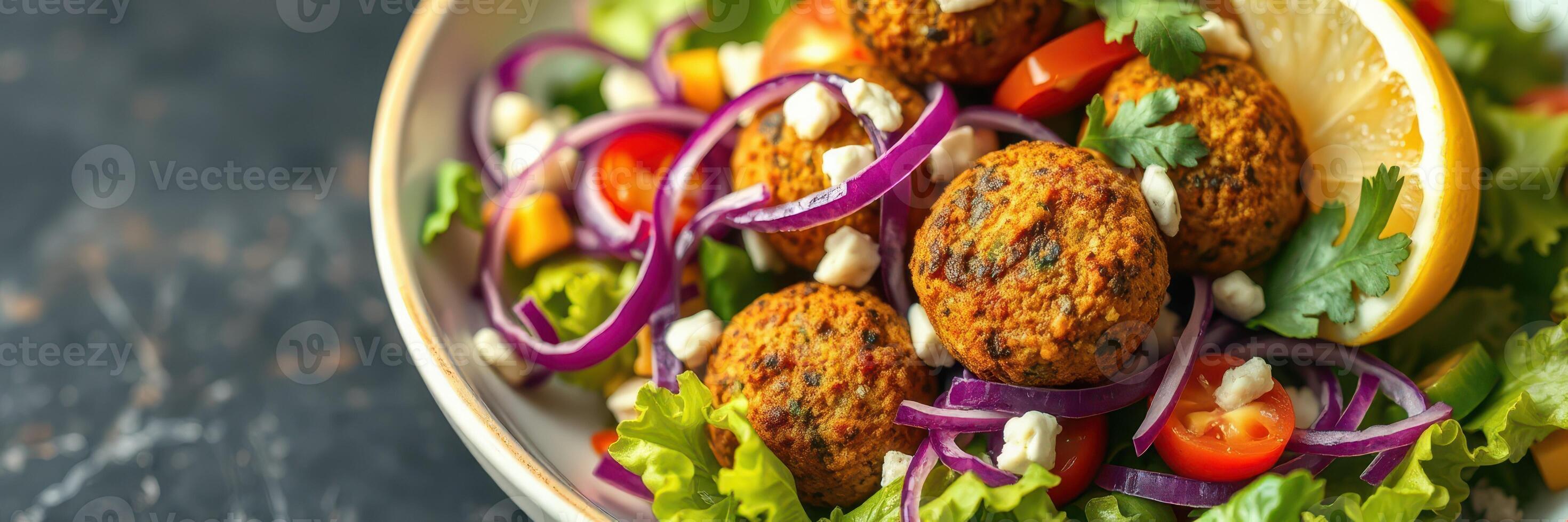 Delicious falafel salad with fresh vegetables and lemon served in a bowl photo