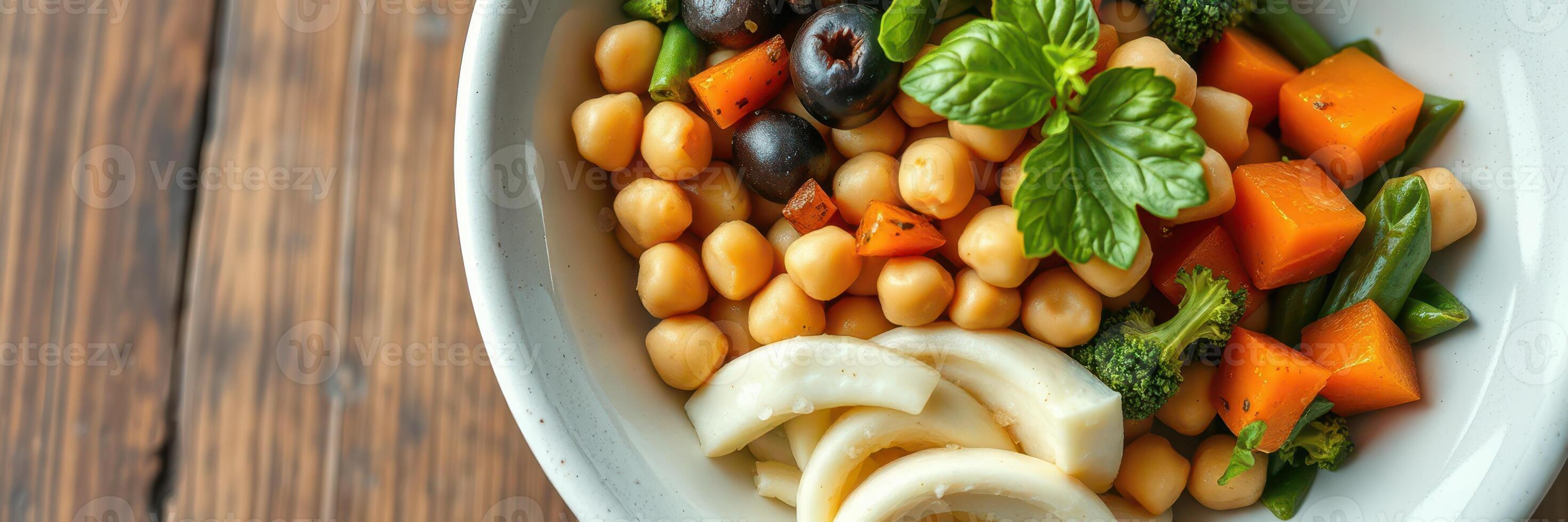 Colorful and nutritious salad with chickpeas, vegetables, and fruits served in a white bowl on a wooden table photo