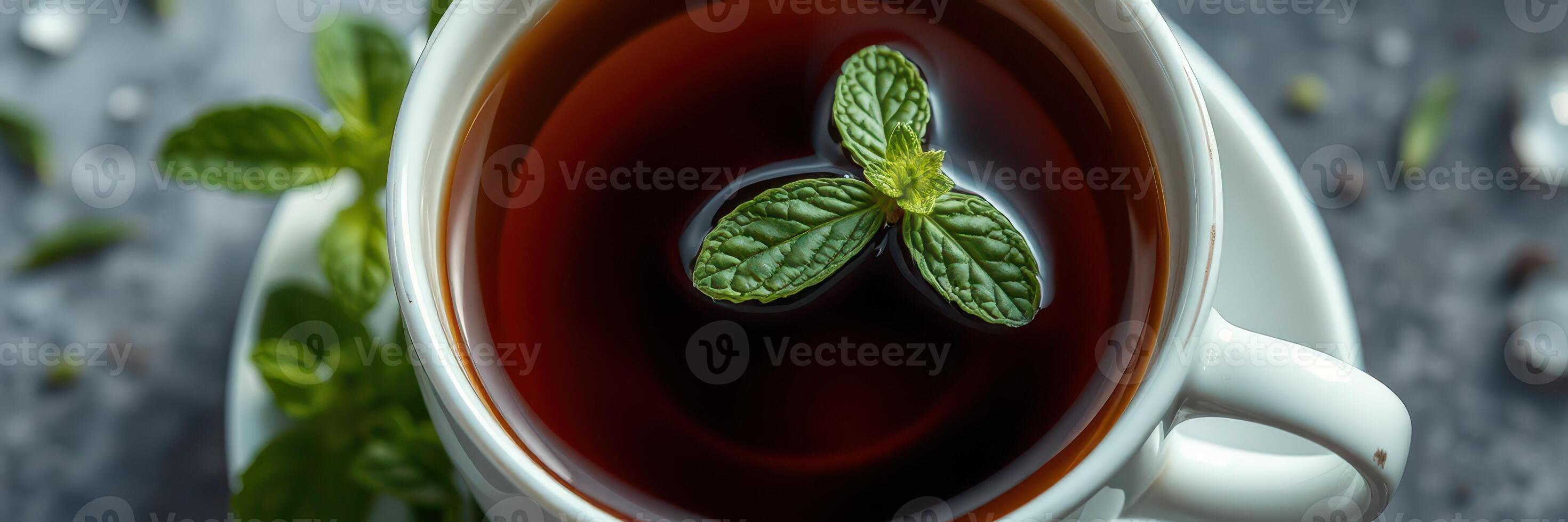 Enjoying a warm cup of herbal tea garnished with fresh mint leaves on a cozy table photo