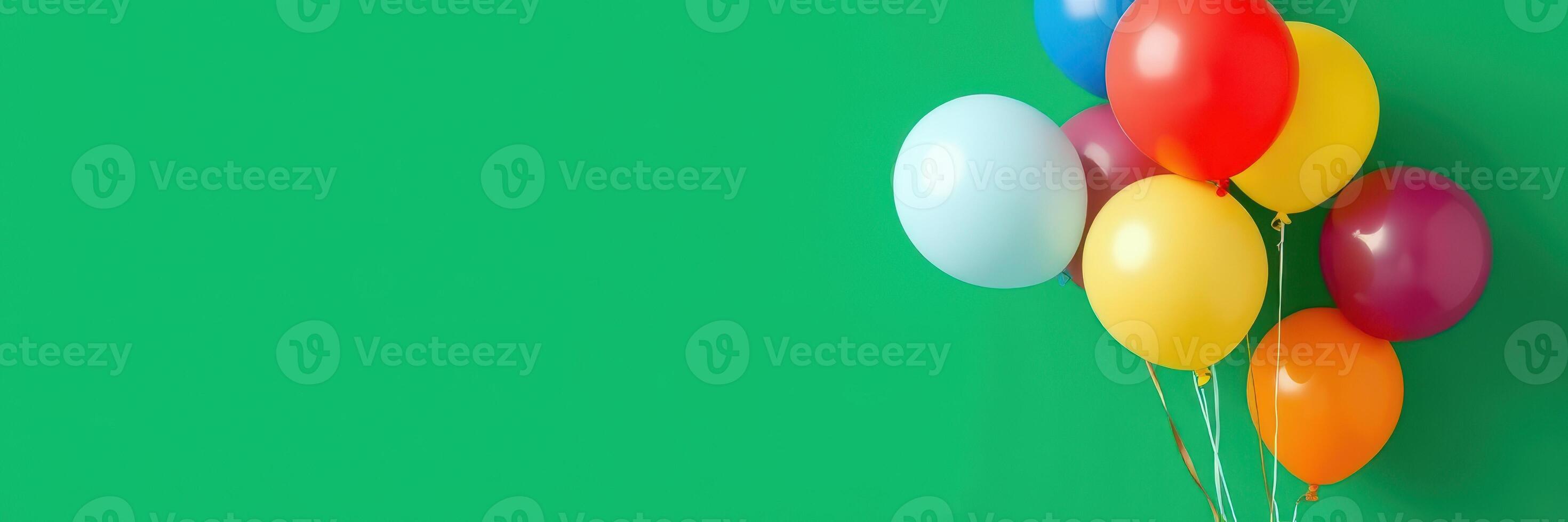 Colorful balloons arranged against a bright green background for a festive celebration or party photo