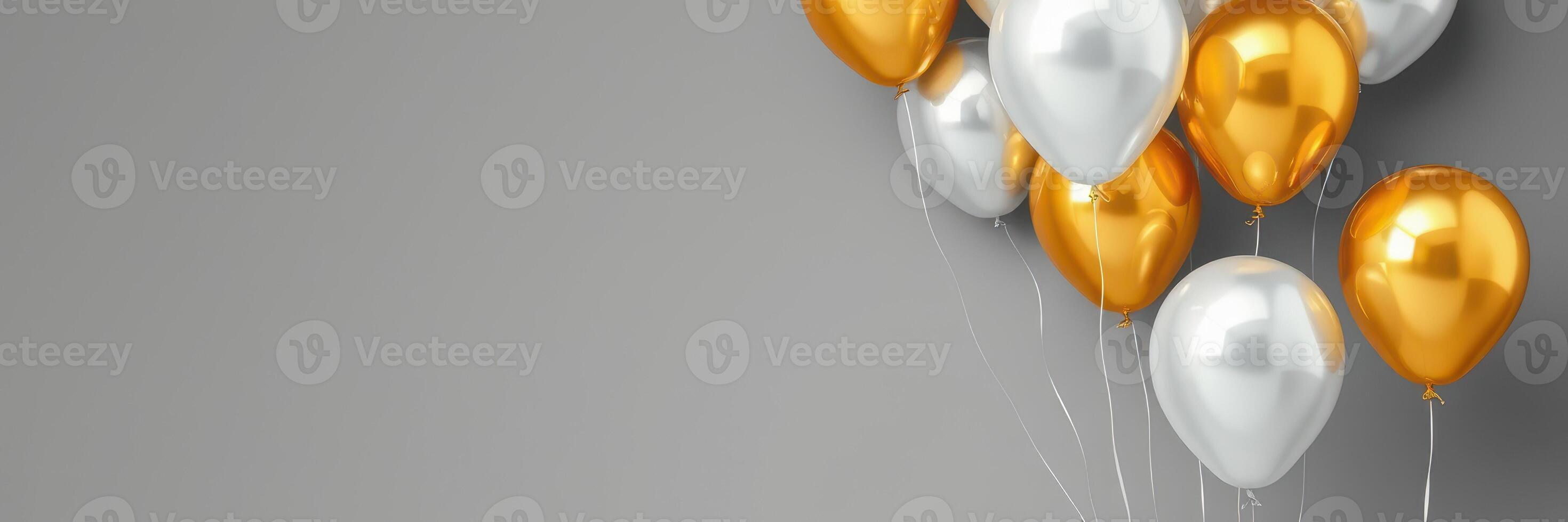 Colorful balloons in silver and gold float against a gray wall for a festive celebration photo