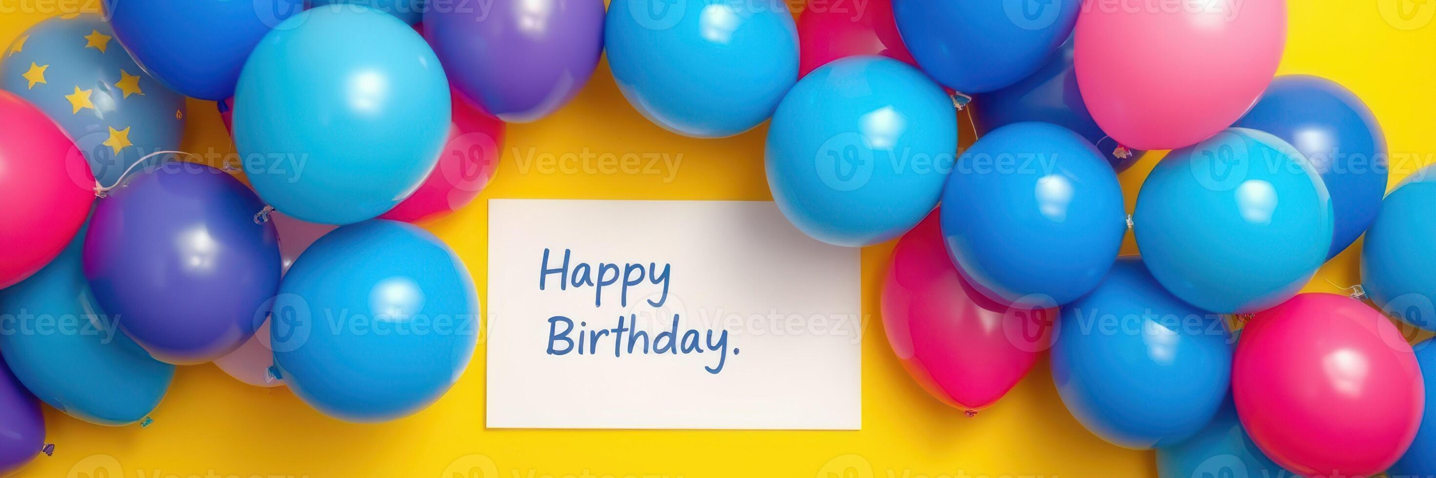 Decorated birthday setting with colorful balloons and a greeting card on a bright yellow background photo