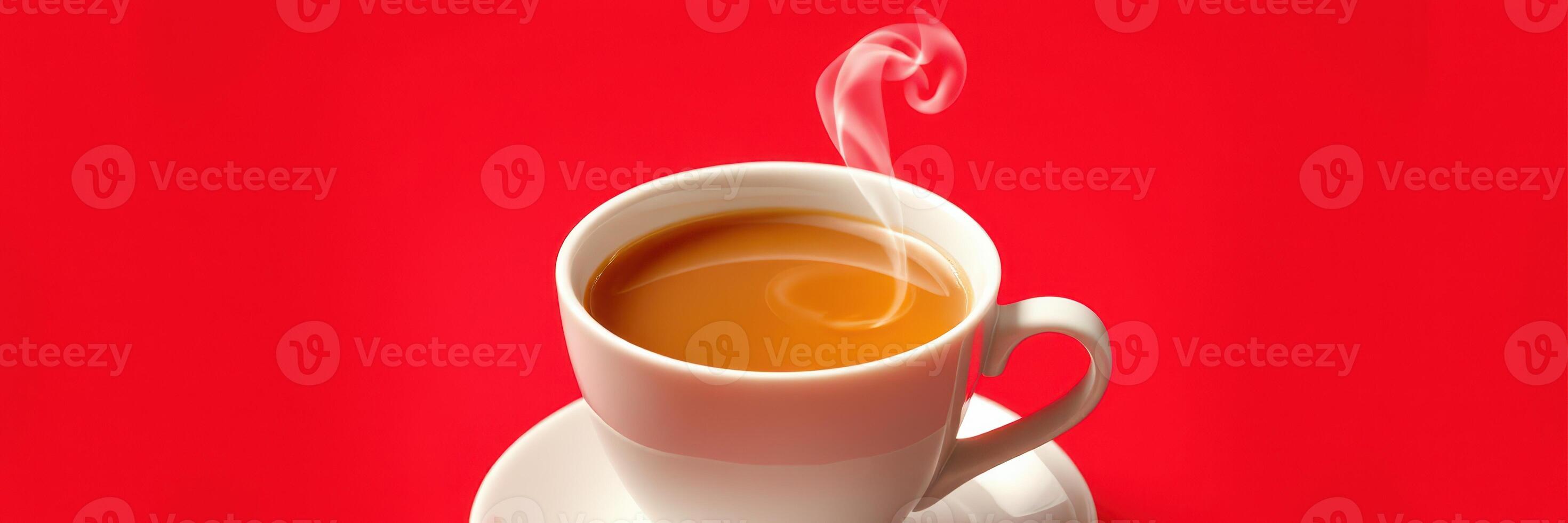 Warm cup of steaming tea resting on a white saucer against a vibrant red background in a cozy setting photo