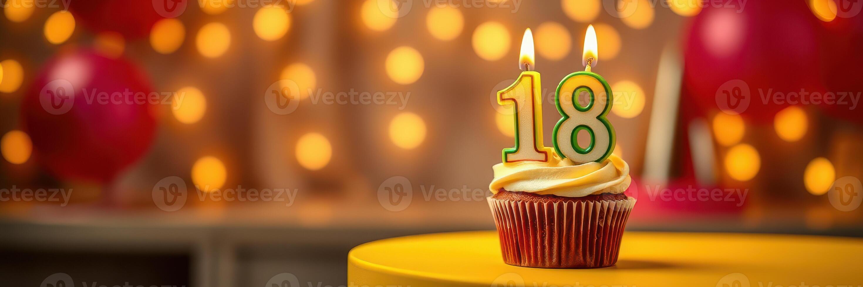 Cupcake topped with two candles celebrating an 18th birthday at a festive party photo