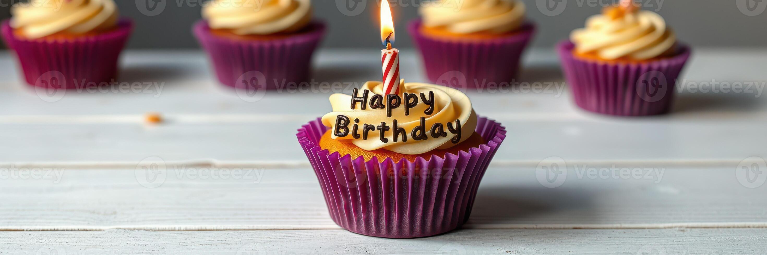 Colorful birthday cupcakes with frosting and candles on a wooden table for a celebration photo