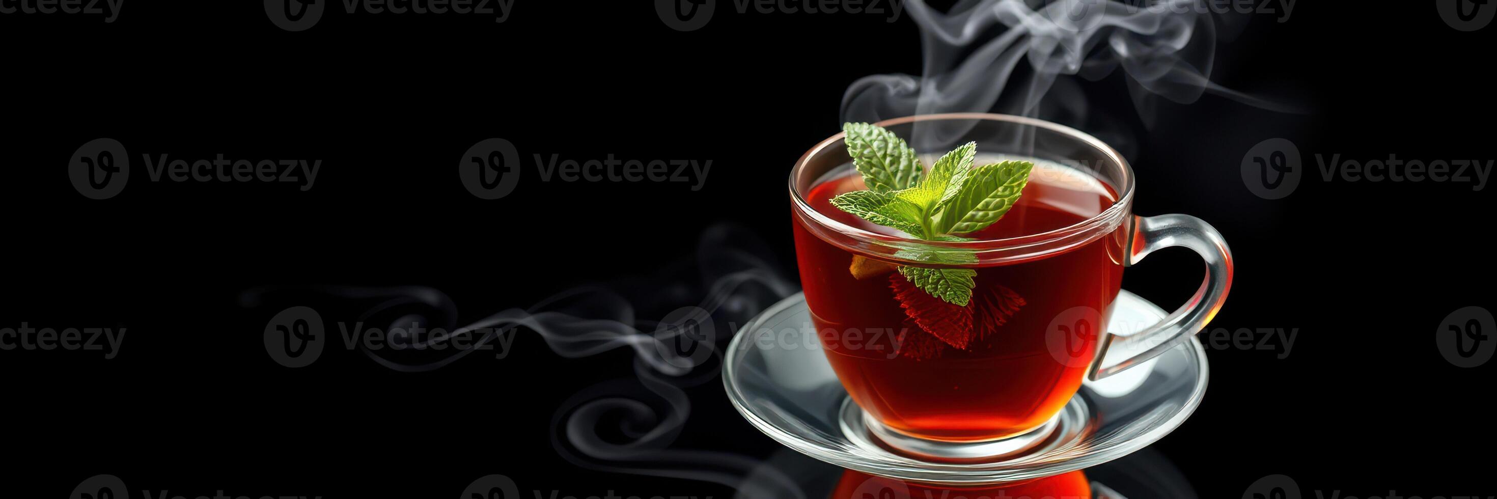 Warm herbal tea served in a clear cup with a fresh mint garnish on a dark background photo