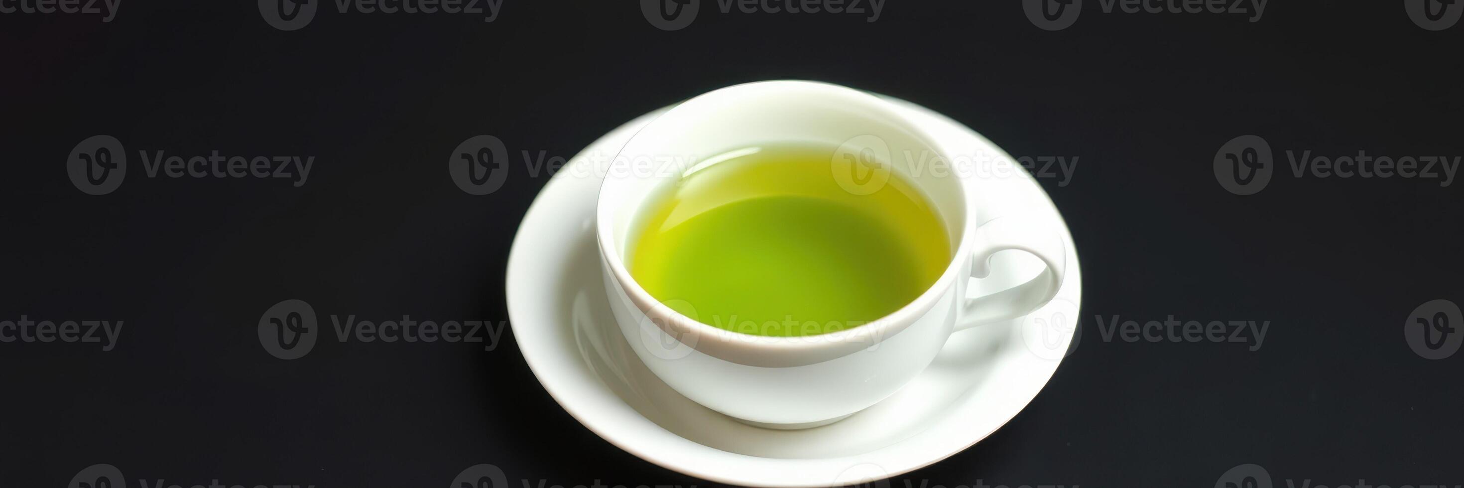 Freshly brewed green tea in a white cup on a dark surface showcasing its vibrant color and inviting aroma photo