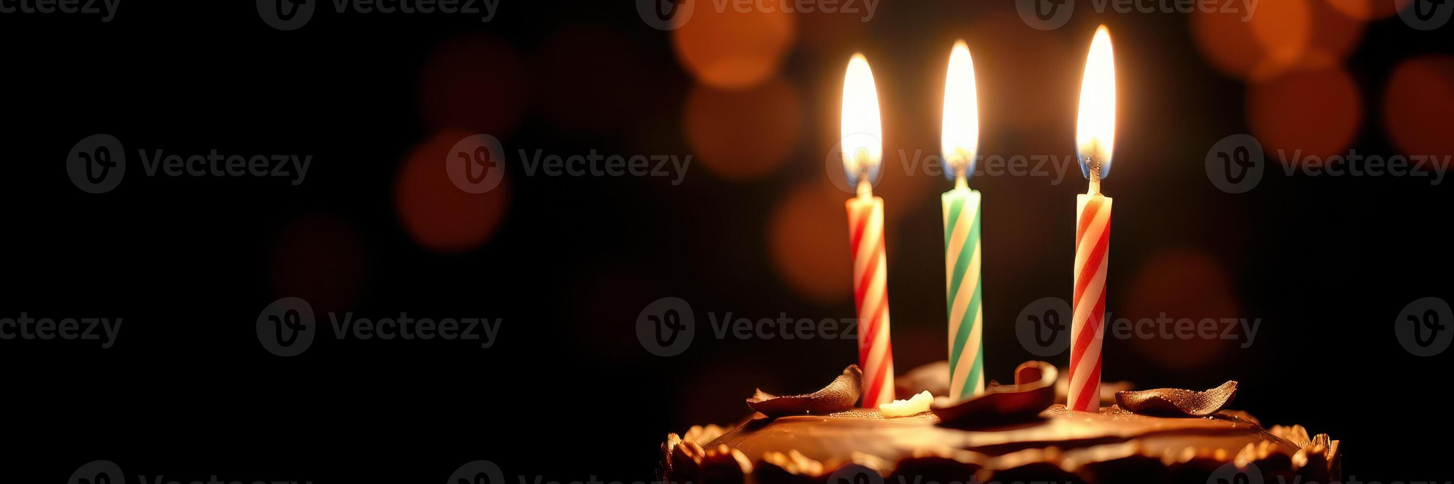 Celebrate a joyful birthday with a chocolate cake adorned with three lit candles casting a warm glow photo