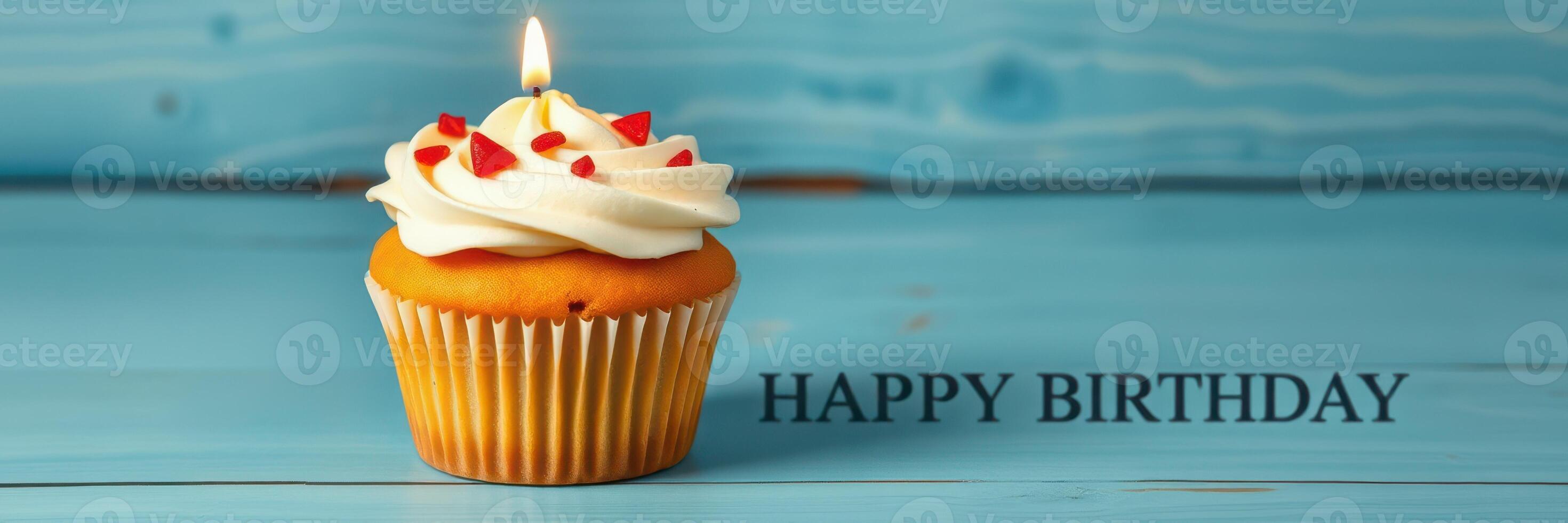 Celebrating a special occasion with a sweet cupcake topped with frosting and a birthday candle on a blue wooden table photo