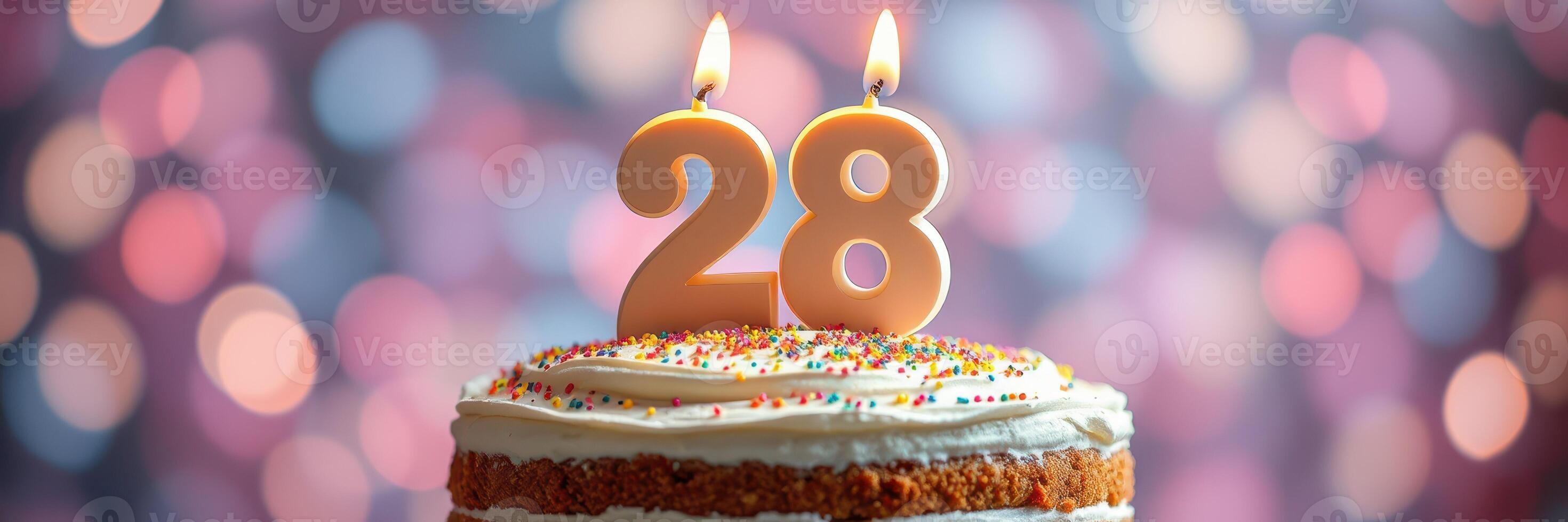 Celebrating a special birthday with a decorated cake featuring the number 28 in candles against a colorful blurred background photo