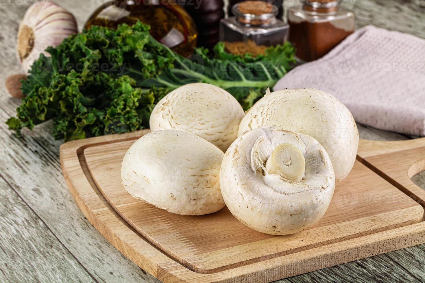 White champignon mushrooms heap over board photo