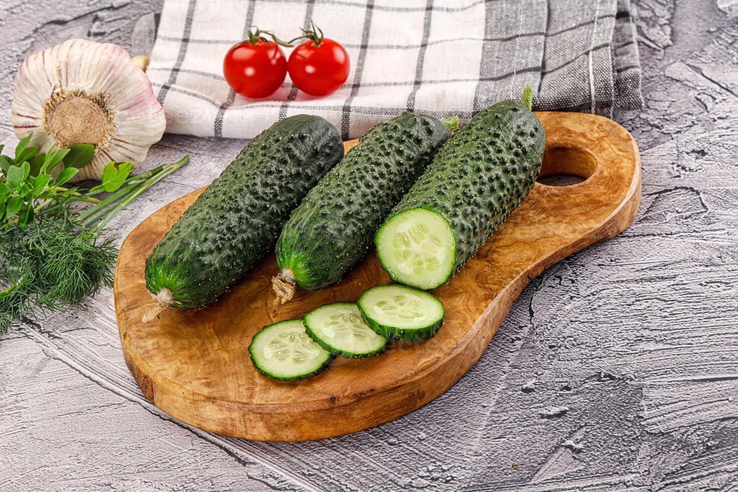 Raw green cucumbers with slices photo