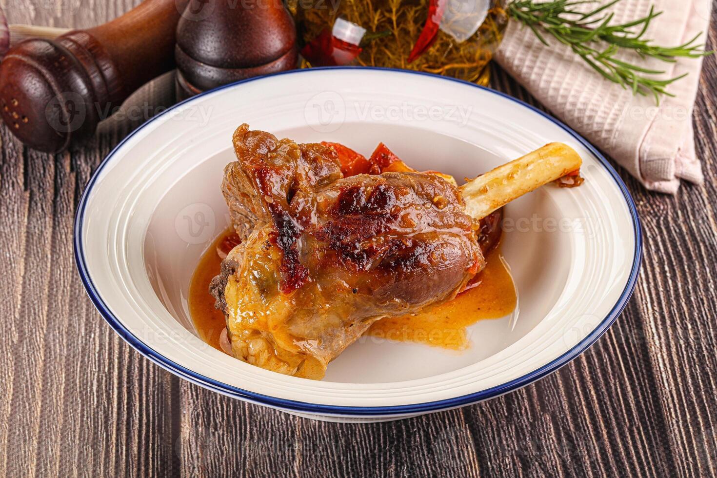 Baked lamb shank with vegetables photo