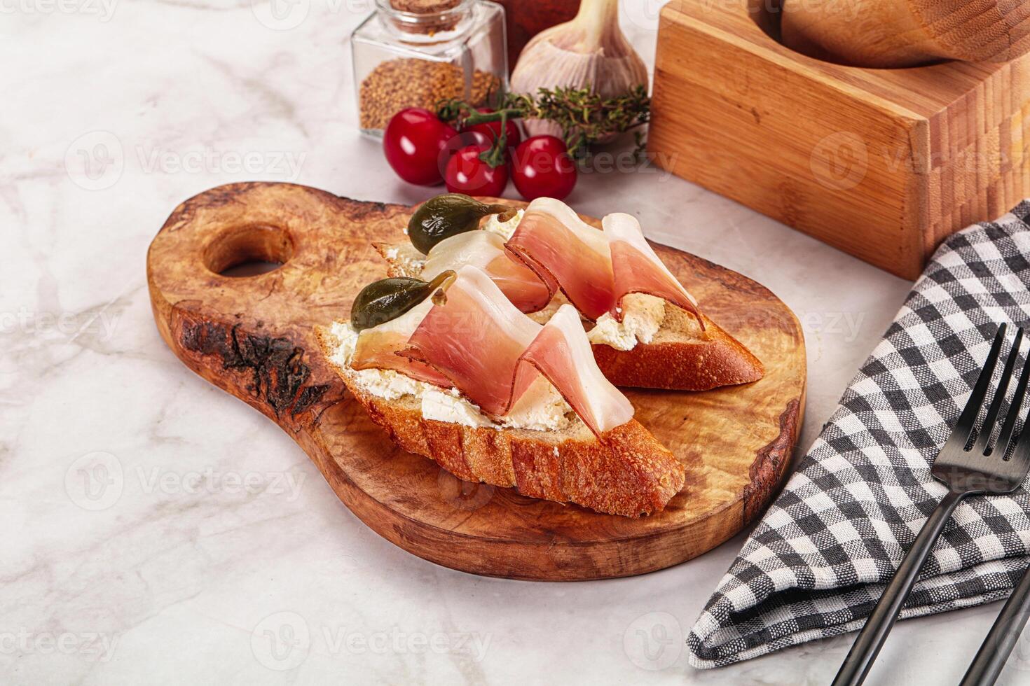 Bruschetta with jamon and caper berries photo