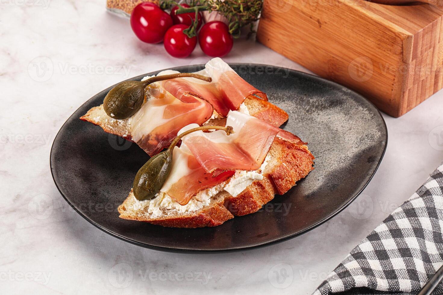 Bruschetta with jamon and caper berries photo