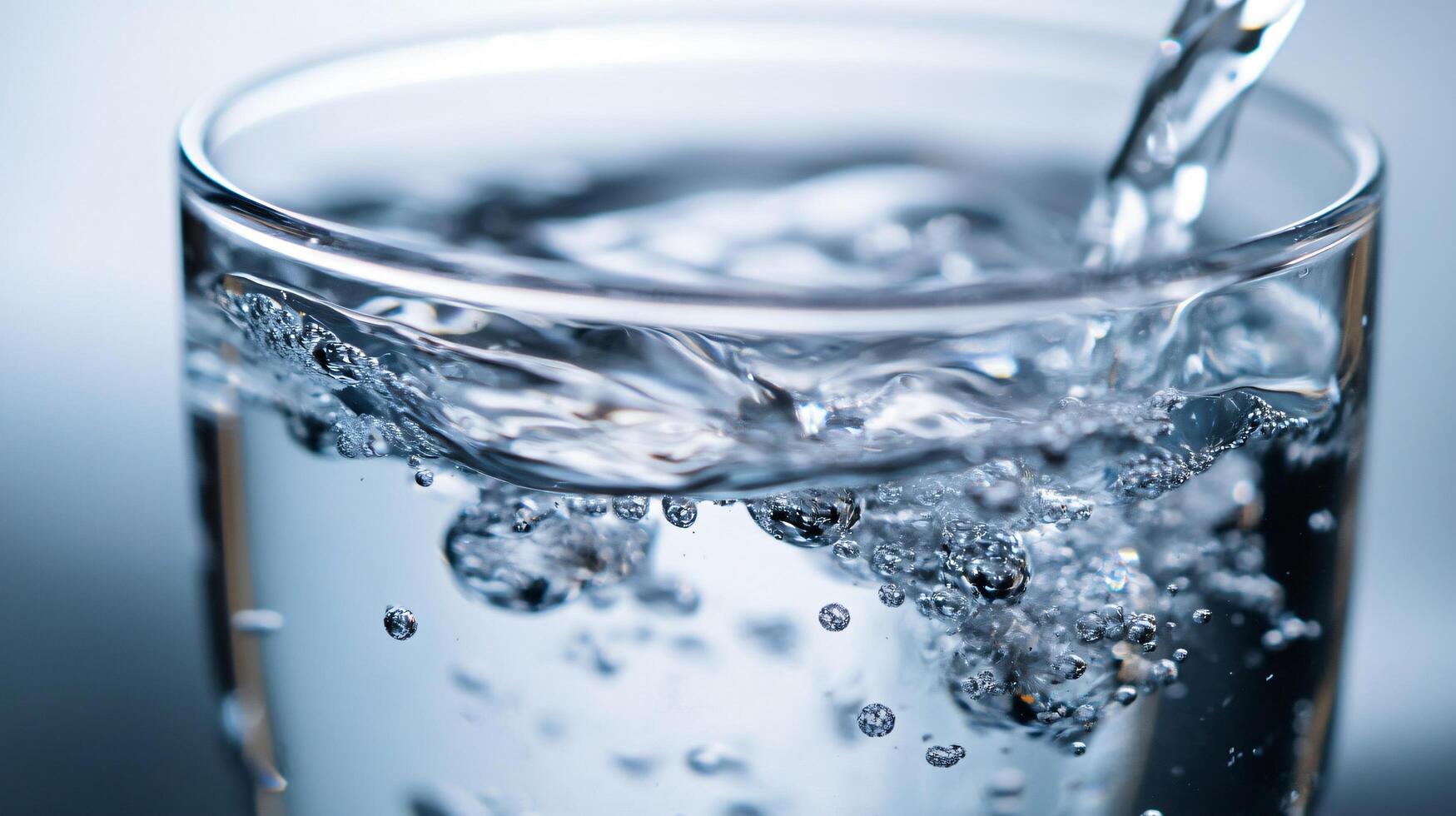 A glass of water is being poured into it photo