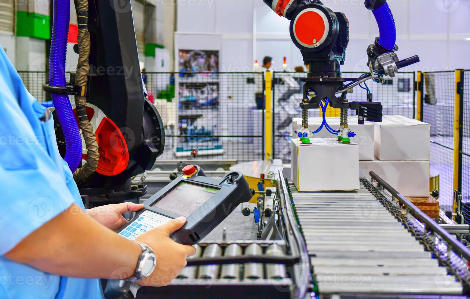 Manager check and control automation robot arms holding a white box and worker operating a robot machine with a control panel photo