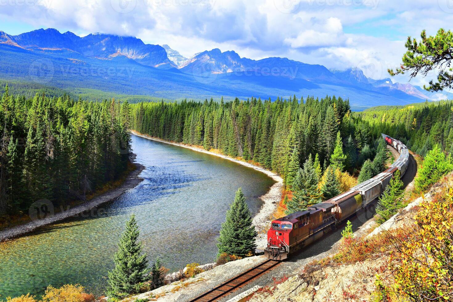 Long freight train moving along Bow river in Canadian Rockies ,Banff National Park, Canadian Rockies,Canada. photo