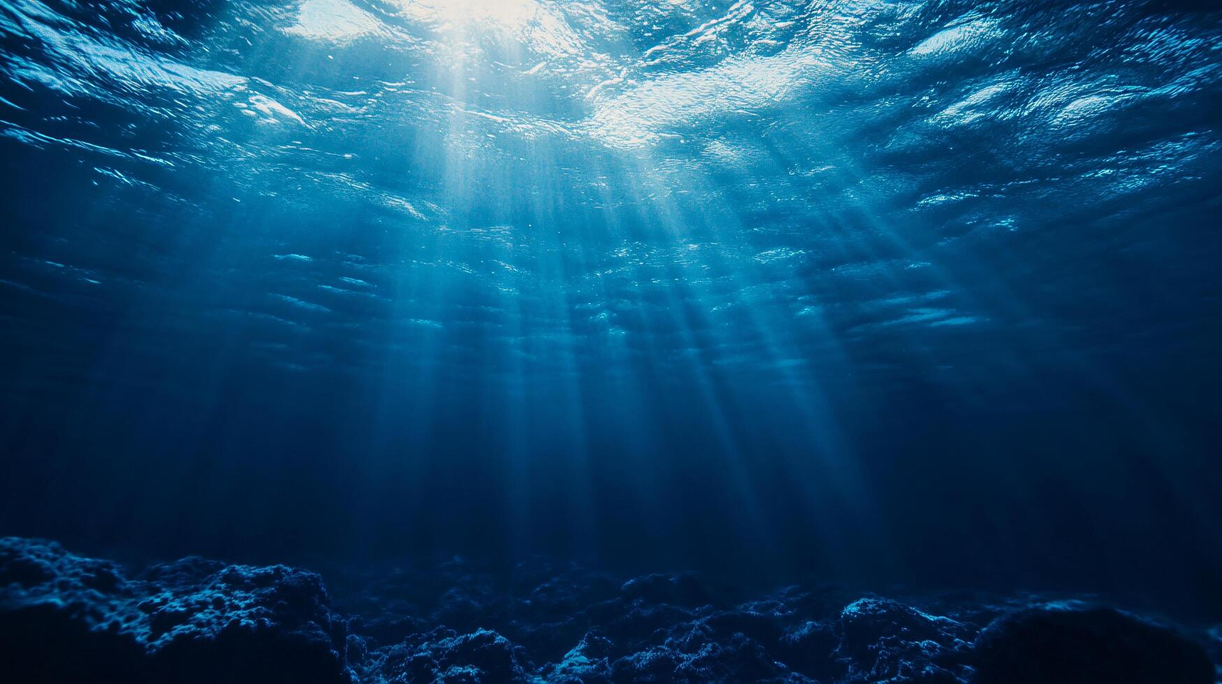 A deep blue ocean with sunlight shining through the water photo