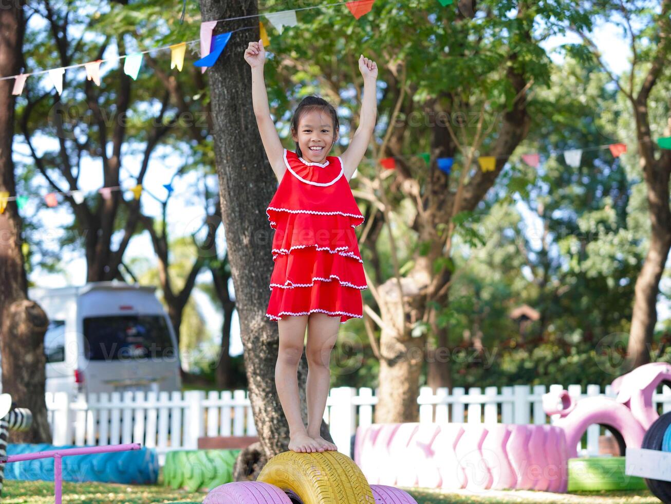 Cute girl playing in the playground during summer vacation. Happy children having fun in an outdoor park. photo