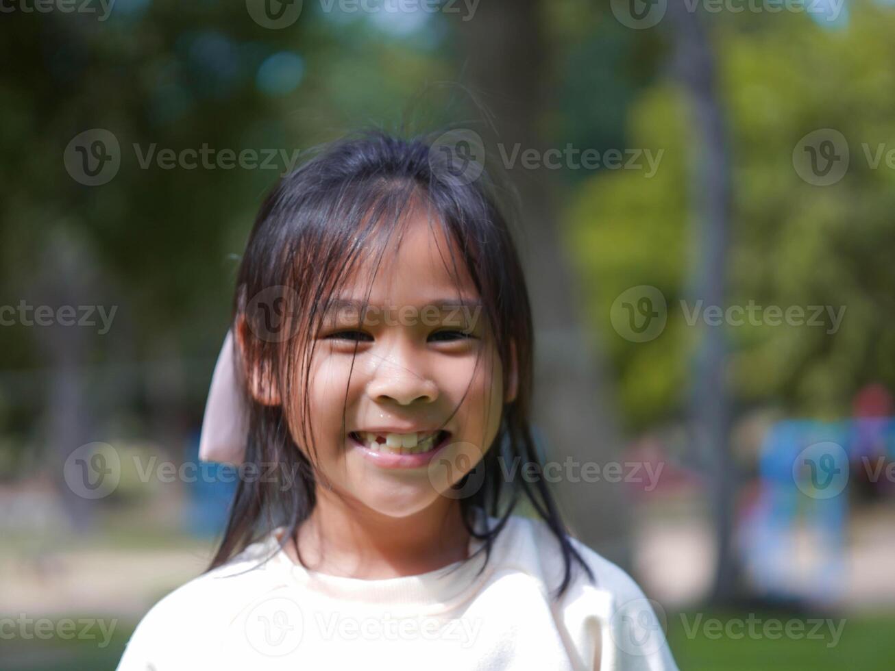 Portrait of a smiling little girl in a park on a sunny day. photo