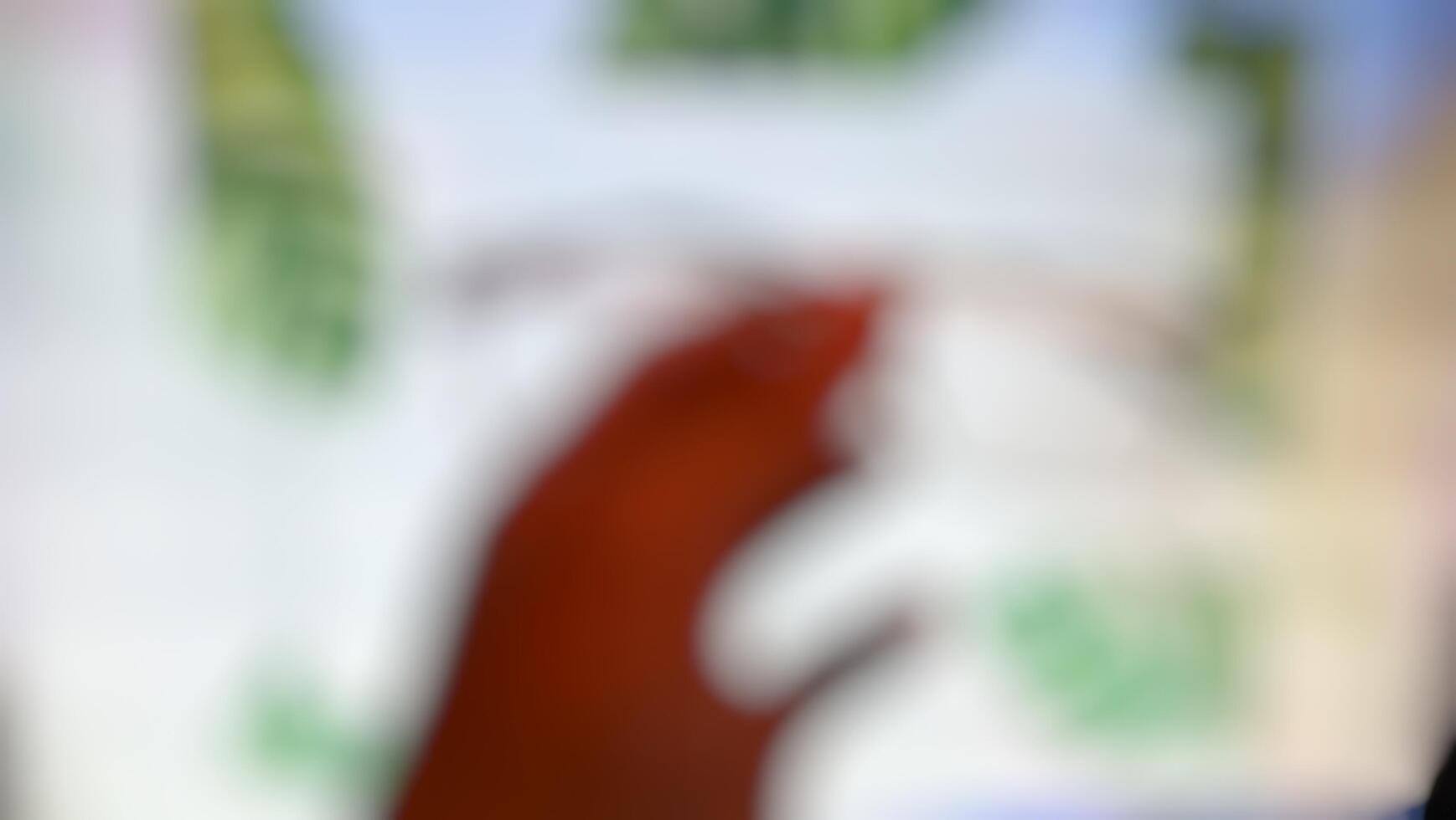 A blurry image of a person holding a phone photo